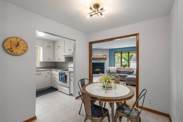 2401 Decatur Ave S, Saint Louis Park, MN 55426 - dining room featuring a fireplace, a chandelier, and baseboards