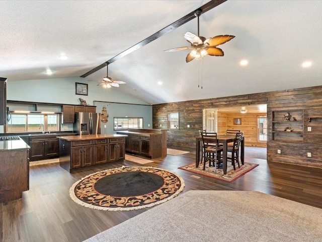 1465 State 84 NW, Backus, MN 56435 - kitchen featuring stainless steel fridge, a center island, a ceiling fan, wooden walls, and dark wood-style floors