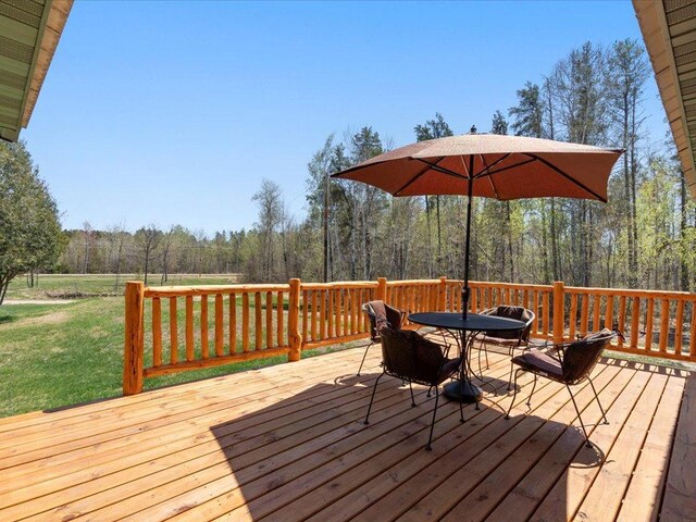 1465 State 84 NW, Backus, MN 56435 - wooden deck with outdoor dining space, a yard, and a view of trees
