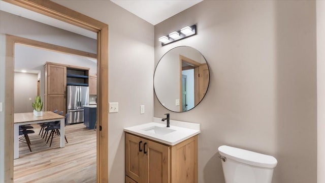 2948 N Oaks Ln NW, Garfield, MN 56332 - half bath featuring vanity, toilet, and wood finished floors