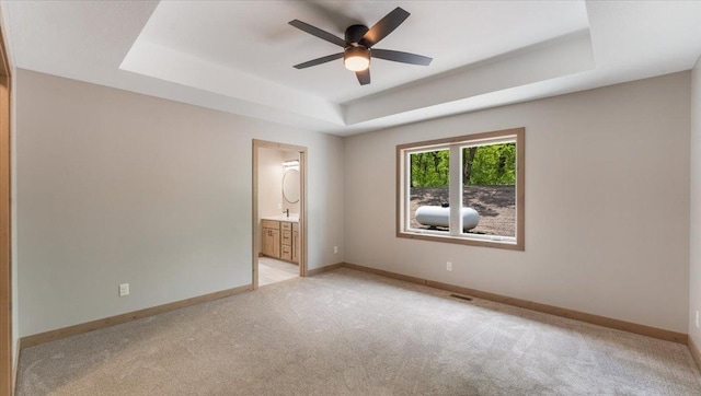2948 N Oaks Ln NW, Garfield, MN 56332 - spare room with a tray ceiling, light colored carpet, ceiling fan, and baseboards