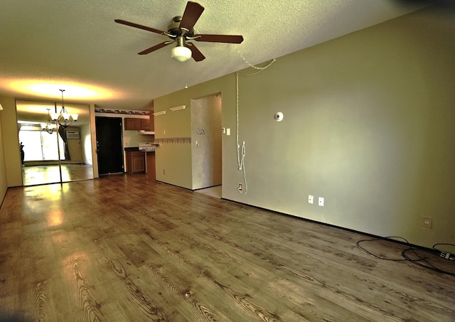 unfurnished living room with a textured ceiling, a chandelier, wood finished floors, and a ceiling fan
