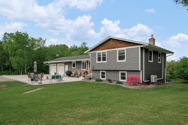11946 180th St, Milaca Twp, MN 56353 - back of property with a chimney, an attached garage, a patio, a yard, and driveway