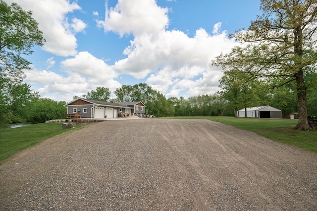 11946 180th St, Milaca Twp, MN 56353 - view of front of property featuring driveway, a front lawn, an attached garage, and a pole building