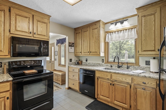 11946 180th St, Milaca Twp, MN 56353 - kitchen featuring black appliances, a sink, light tile patterned floors, light stone counters, and a textured ceiling
