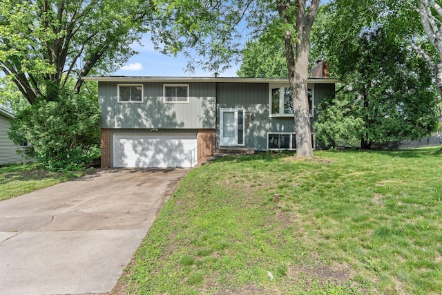 3225 Hillsboro Ave N, New Hope, MN 55427 - split foyer home featuring a garage, a front yard, concrete driveway, and a chimney