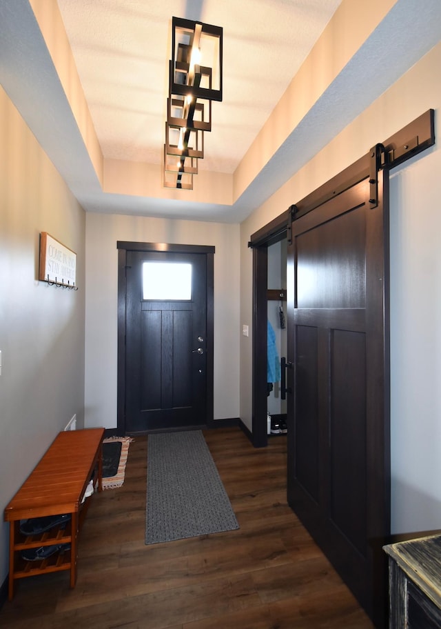 1800 20th Avenue Cir NE, Kasson, MN 55944 - entryway with a barn door, a tray ceiling, wood finished floors, and baseboards