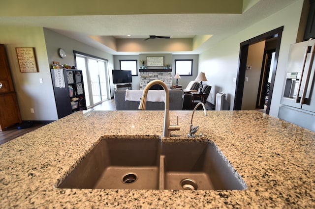 1800 20th Avenue Cir NE, Kasson, MN 55944 - kitchen with a sink, light stone counters, stainless steel fridge with ice dispenser, ceiling fan, and wood finished floors
