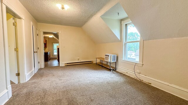 226 3rd Ave NE, Saint Cloud, MN 56304 - additional living space featuring baseboard heating, a wall mounted air conditioner, carpet flooring, a textured ceiling, and lofted ceiling