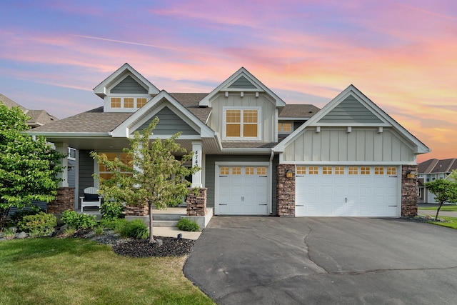 4740 Ashton Curv, Woodbury, MN 55129 - view of front of property featuring board and batten siding, asphalt driveway, stone siding, roof with shingles, and a lawn