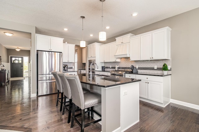 4740 Ashton Curv, Woodbury, MN 55129 - kitchen featuring stainless steel appliances, premium range hood, a sink, an island with sink, and decorative backsplash