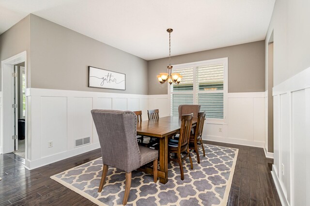 4740 Ashton Curv, Woodbury, MN 55129 - dining space featuring a chandelier, dark wood-style flooring, a decorative wall, and wainscoting