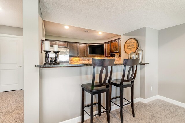 4740 Ashton Curv, Woodbury, MN 55129 - kitchen with carpet flooring, dark brown cabinets, a peninsula, tasteful backsplash, and recessed lighting