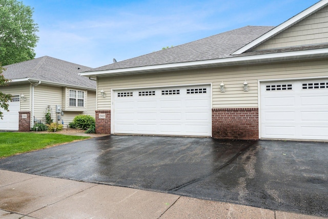 13403 96th Pl N, Maple Grove, MN 55369 - view of side of property with brick siding, asphalt driveway, and roof with shingles