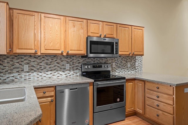 13403 96th Pl N, Maple Grove, MN 55369 - kitchen with stainless steel appliances, a peninsula, decorative backsplash, and light stone counters