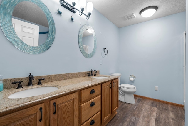 13403 96th Pl N, Maple Grove, MN 55369 - full bathroom featuring double vanity, toilet, wood finished floors, a textured ceiling, and baseboards