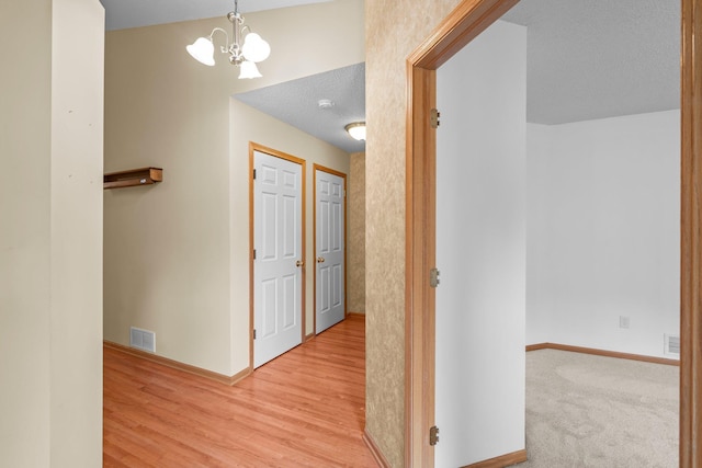 13403 96th Pl N, Maple Grove, MN 55369 - corridor featuring a chandelier, baseboards, wood finished floors, and a textured ceiling