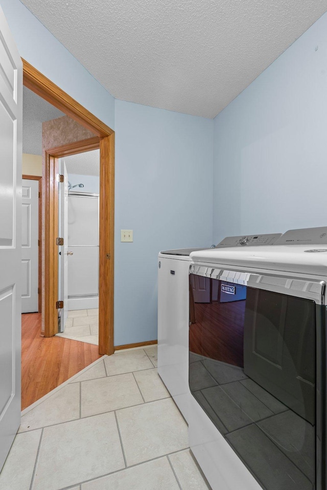 13403 96th Pl N, Maple Grove, MN 55369 - washroom featuring washing machine and dryer, a textured ceiling, light tile patterned flooring, and baseboards