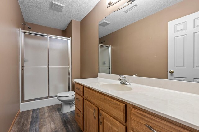 13403 96th Pl N, Maple Grove, MN 55369 - full bathroom with wood finished floors, vanity, a stall shower, toilet, and a textured ceiling