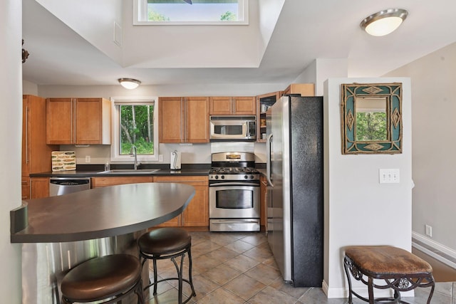 3806 Sunset Dr, Spring Park, MN 55384 - kitchen with appliances with stainless steel finishes, a sink, dark countertops, and brown cabinets