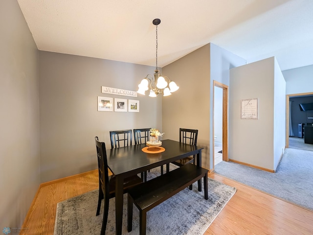 dining space with a chandelier, light wood-type flooring, and baseboards