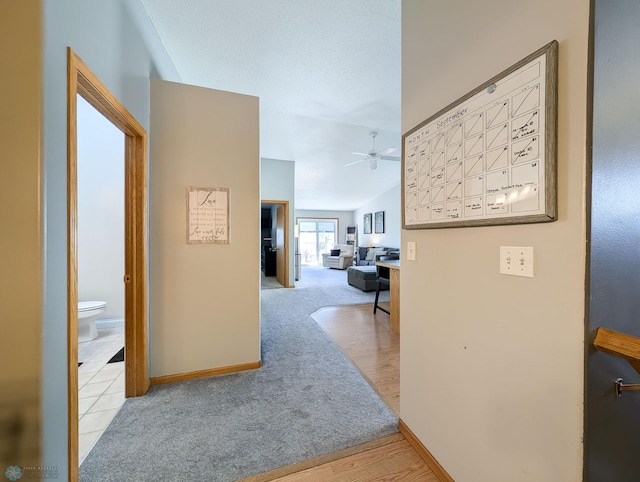 corridor with carpet flooring and baseboards