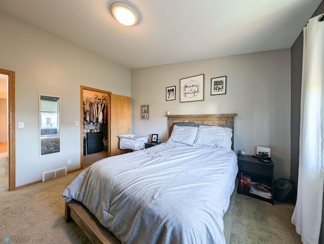 carpeted bedroom with a spacious closet and a closet