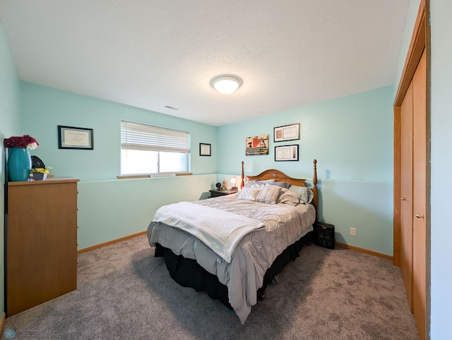 bedroom with carpet, a textured ceiling, and baseboards