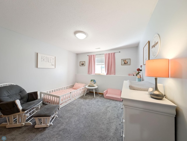carpeted bedroom with a nursery area and a textured ceiling