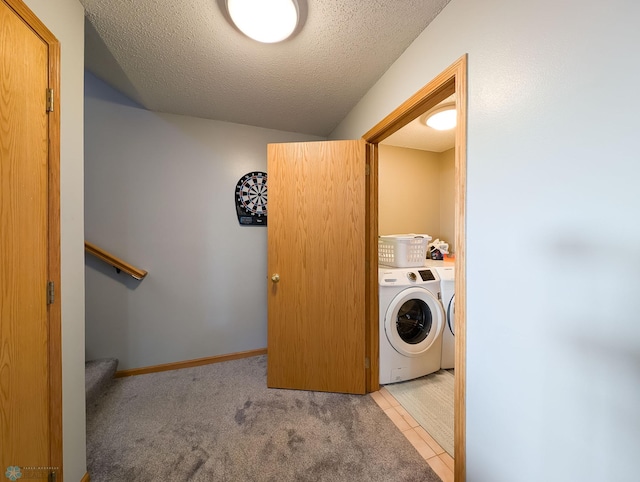 laundry room featuring washing machine and clothes dryer and a textured ceiling