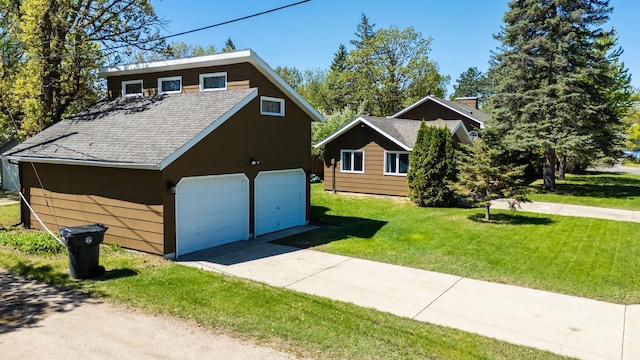 300 27th St NE, Bemidji, MN 56601 - view of front facade featuring a detached garage, a shingled roof, and a front yard