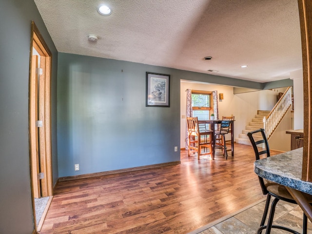 300 27th St NE, Bemidji, MN 56601 - dining room with a textured ceiling, stairs, wood finished floors, baseboards, and recessed lighting
