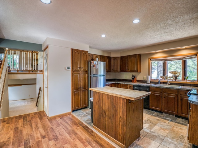 300 27th St NE, Bemidji, MN 56601 - kitchen with butcher block countertops, freestanding refrigerator, dishwasher, a textured ceiling, and a sink