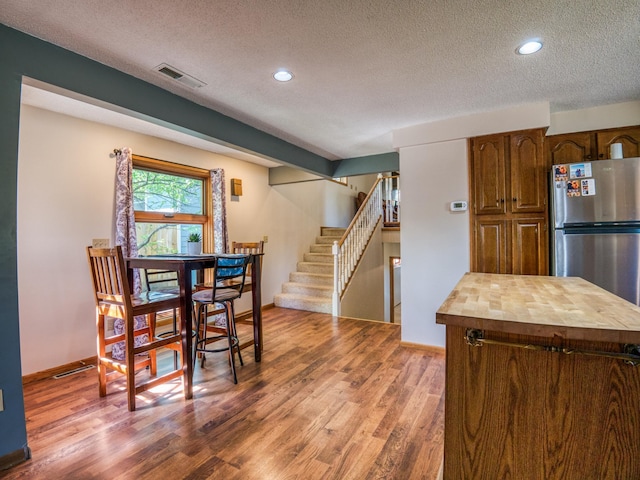 300 27th St NE, Bemidji, MN 56601 - dining space with a textured ceiling, wood finished floors, stairway, recessed lighting, and baseboards