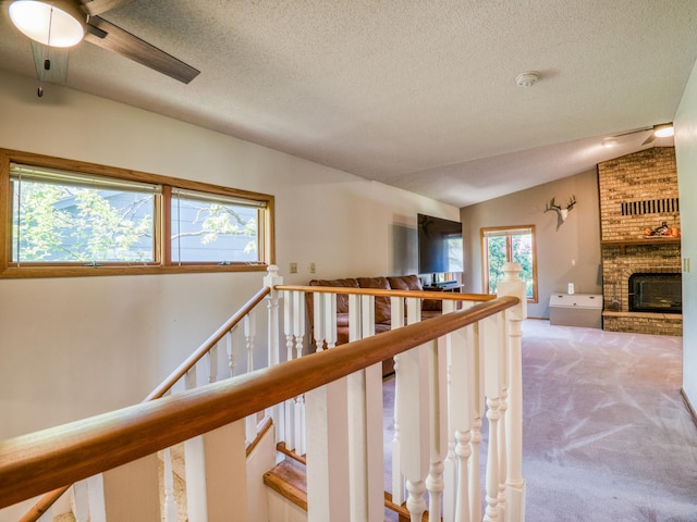 300 27th St NE, Bemidji, MN 56601 - hall with an upstairs landing, a textured ceiling, carpet floors, and vaulted ceiling