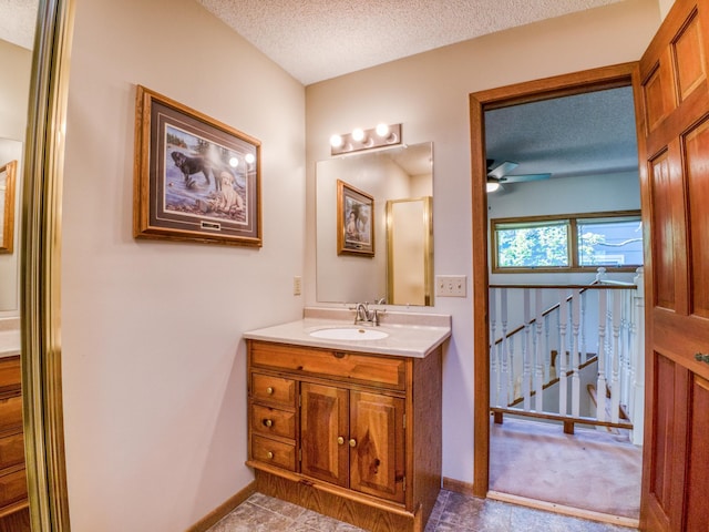 300 27th St NE, Bemidji, MN 56601 - bathroom with a textured ceiling, vanity, a ceiling fan, and baseboards