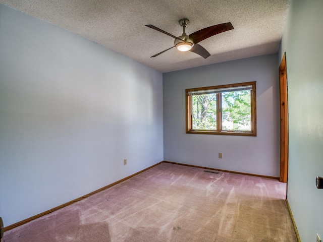 300 27th St NE, Bemidji, MN 56601 - spare room featuring light carpet, ceiling fan, a textured ceiling, and baseboards