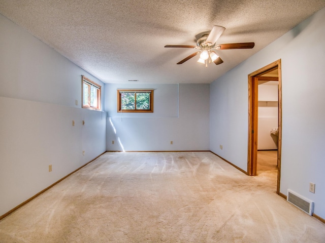 300 27th St NE, Bemidji, MN 56601 - empty room with light carpet, ceiling fan, a textured ceiling, and baseboards