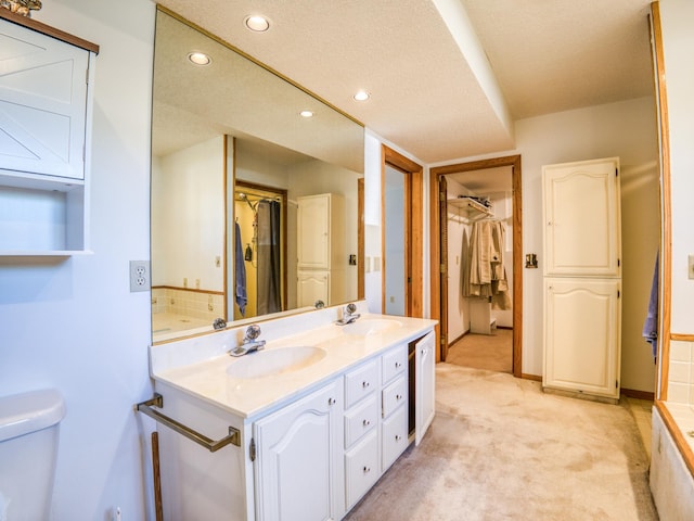 300 27th St NE, Bemidji, MN 56601 - bathroom featuring double vanity, recessed lighting, toilet, and a walk in closet
