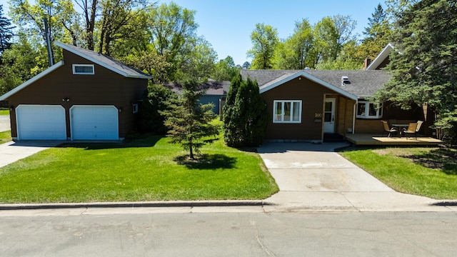 300 27th St NE, Bemidji, MN 56601 - view of front facade featuring a front yard, concrete driveway, a shingled roof, and a detached garage