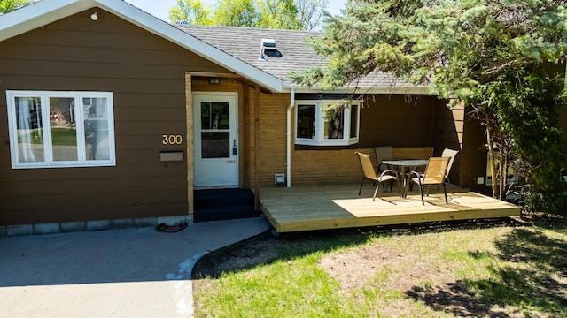 300 27th St NE, Bemidji, MN 56601 - back of property with a deck, roof with shingles, and outdoor dining area