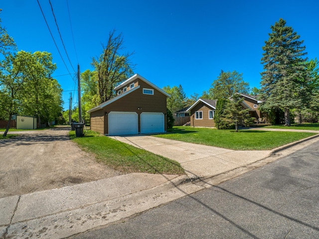 300 27th St NE, Bemidji, MN 56601 - view of front of home featuring an outdoor structure, a garage, concrete driveway, and a front lawn