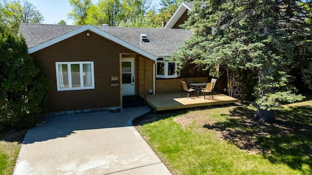 300 27th St NE, Bemidji, MN 56601 - view of front of home featuring roof with shingles, a deck, and a front lawn