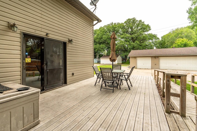 504 Laurel St, Fergus Falls, MN 56537 - wooden terrace with outdoor dining space, an outdoor structure, and a detached garage
