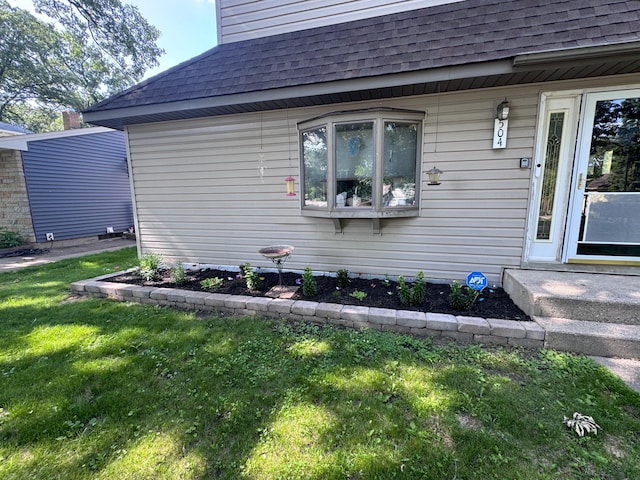 504 Laurel St, Fergus Falls, MN 56537 - view of exterior entry featuring roof with shingles and a lawn