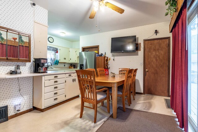 504 Laurel St, Fergus Falls, MN 56537 - dining space featuring wallpapered walls, ceiling fan, and light colored carpet