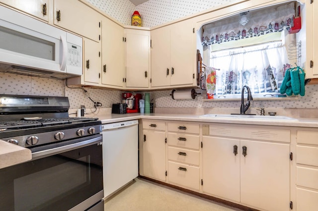 504 Laurel St, Fergus Falls, MN 56537 - kitchen featuring white appliances, light countertops, wallpapered walls, and decorative backsplash