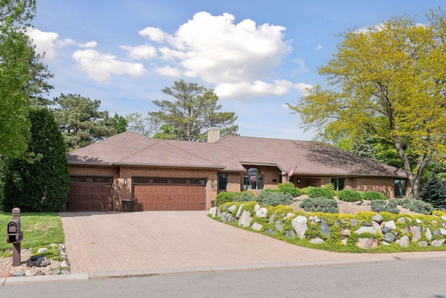 21273 Floral Bay Dr N, Forest Lake, MN 55025 - view of front of home with a garage, driveway, brick siding, and a chimney