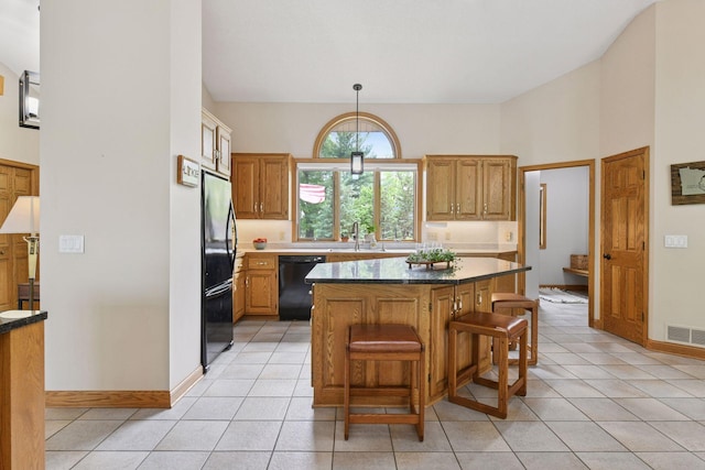 21273 Floral Bay Dr N, Forest Lake, MN 55025 - kitchen featuring black appliances, a kitchen bar, a kitchen island, light tile patterned flooring, and pendant lighting