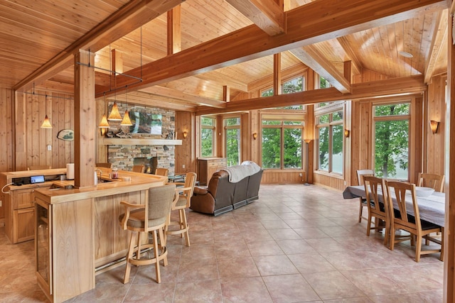 21273 Floral Bay Dr N, Forest Lake, MN 55025 - kitchen with open floor plan, wood walls, wood ceiling, a breakfast bar area, and pendant lighting